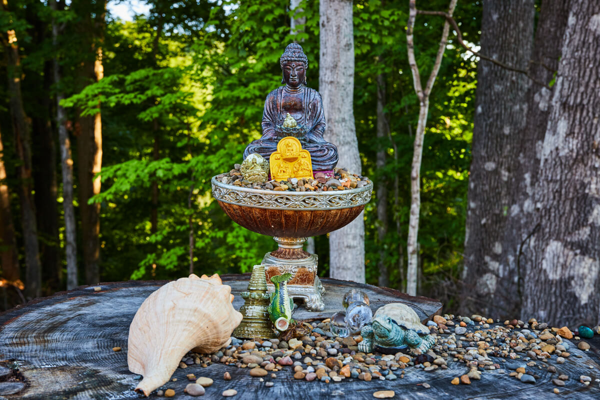 Statue in the woods with offerings