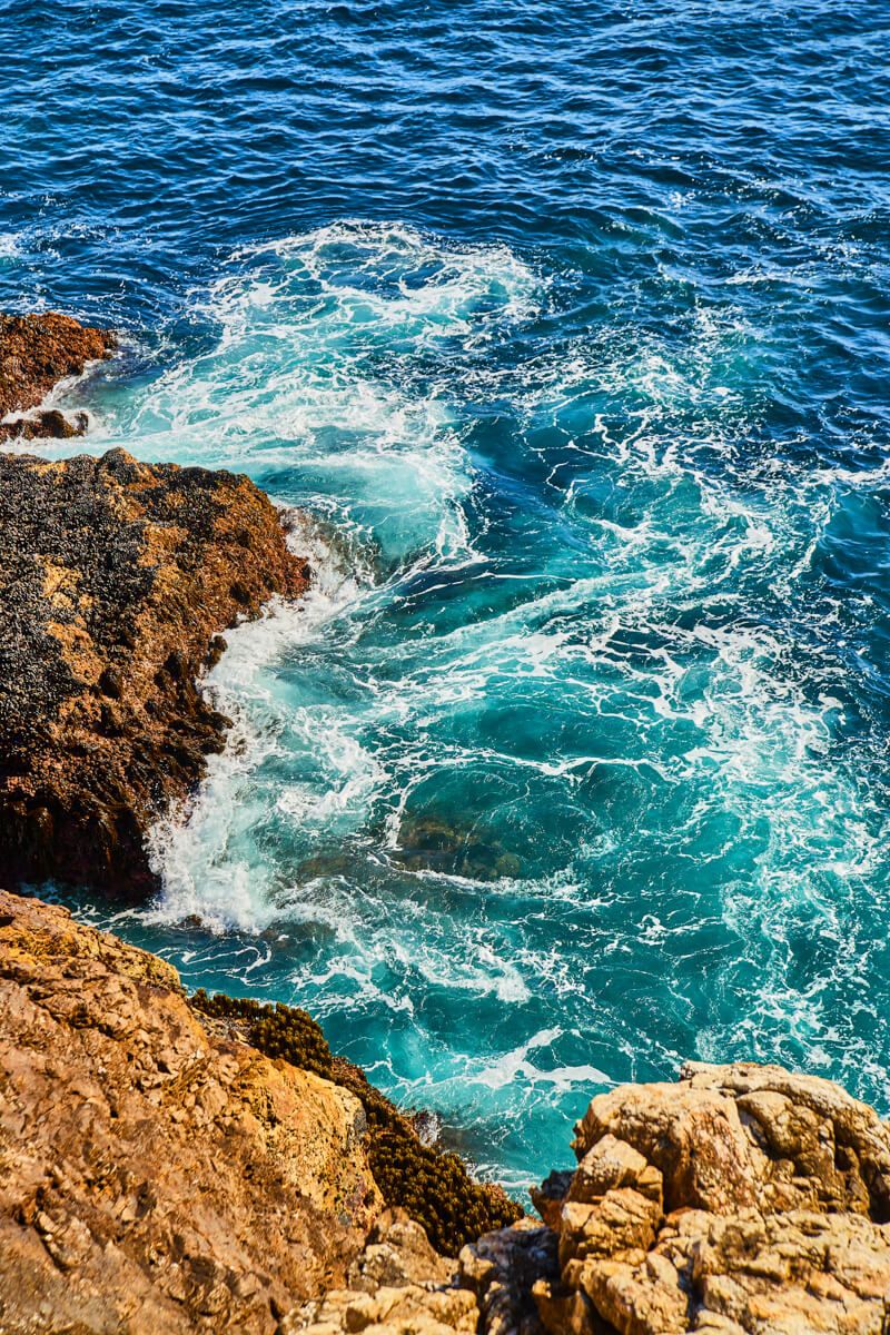 Colorful swirls of ocean water against the cliffs