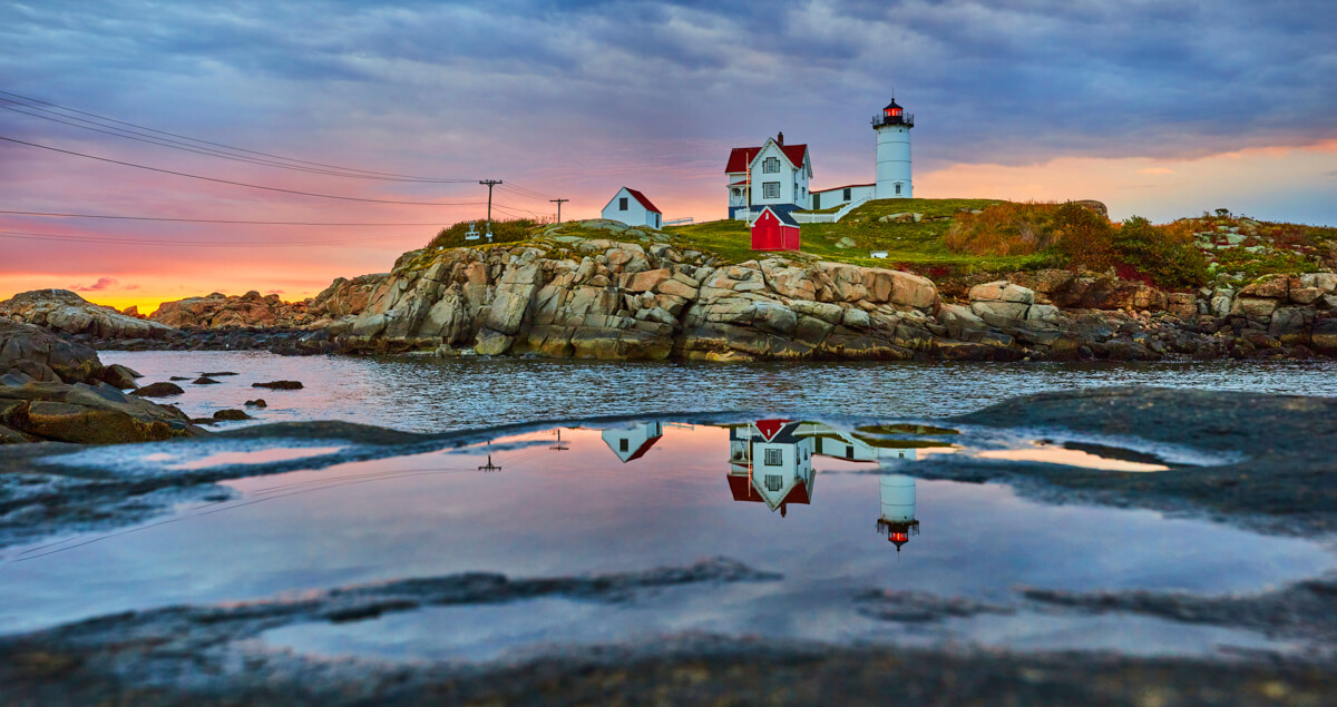 Sunrise light and reflection of lighthouse in puddle