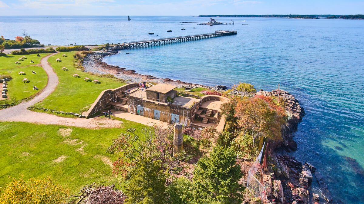 Coastline of military structures, boardwalk, island, and WAY in the distance the Whaleback lighthouse